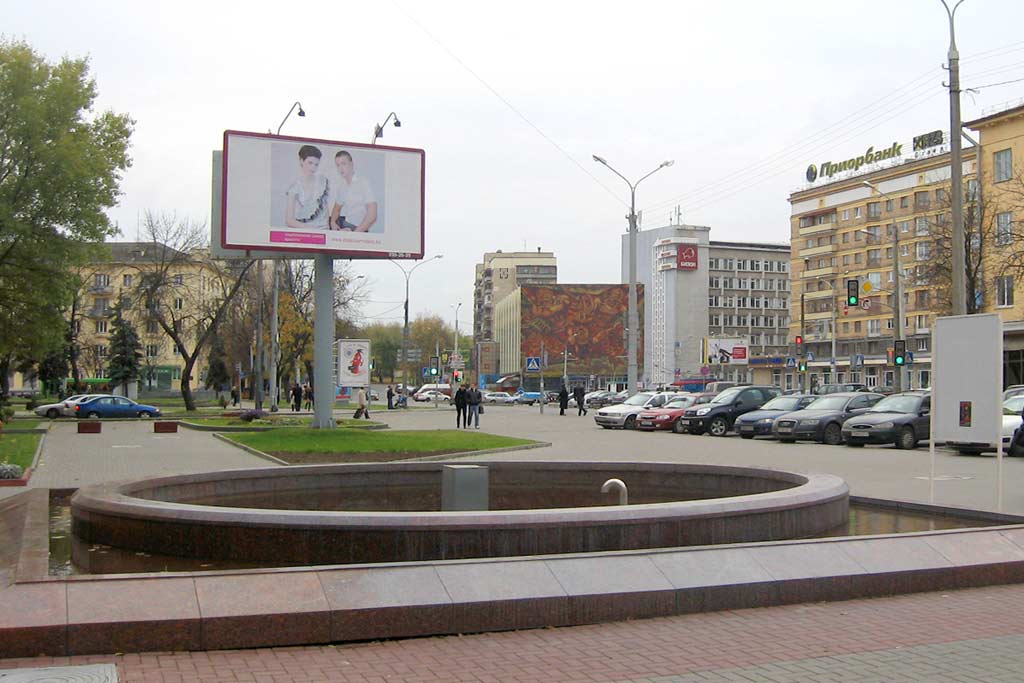 Юбилейная площадь. Слева под елочками - вход в метро Фрунзенская, на дальнем плане - улица Кальварийская. Фото. Картинка